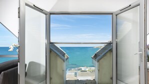 A room with a sliding glass door leading to a balcony with a view of the sea. - The Penthouse Fistral Beach -  an apartment overlooking Fistral Beach sleeping six (Newquay)