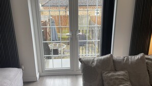 A room with a sliding glass door leading to a patio area. - 2 Bedroom River House St Neots (Saint Neots)