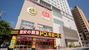 Un edificio con un letrero grande para un restaurante y un letrero más pequeño para una tienda sin impuestos.