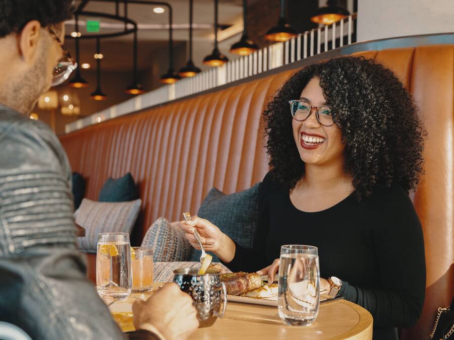 A couple dining at a restaurant with a booth seating arrangement.