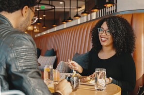 A couple dining at a restaurant with a booth seating arrangement.