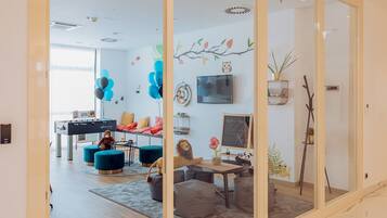 Relax in a comfortable seating area with a sofa and ottomans, and enjoy the view from the large window.