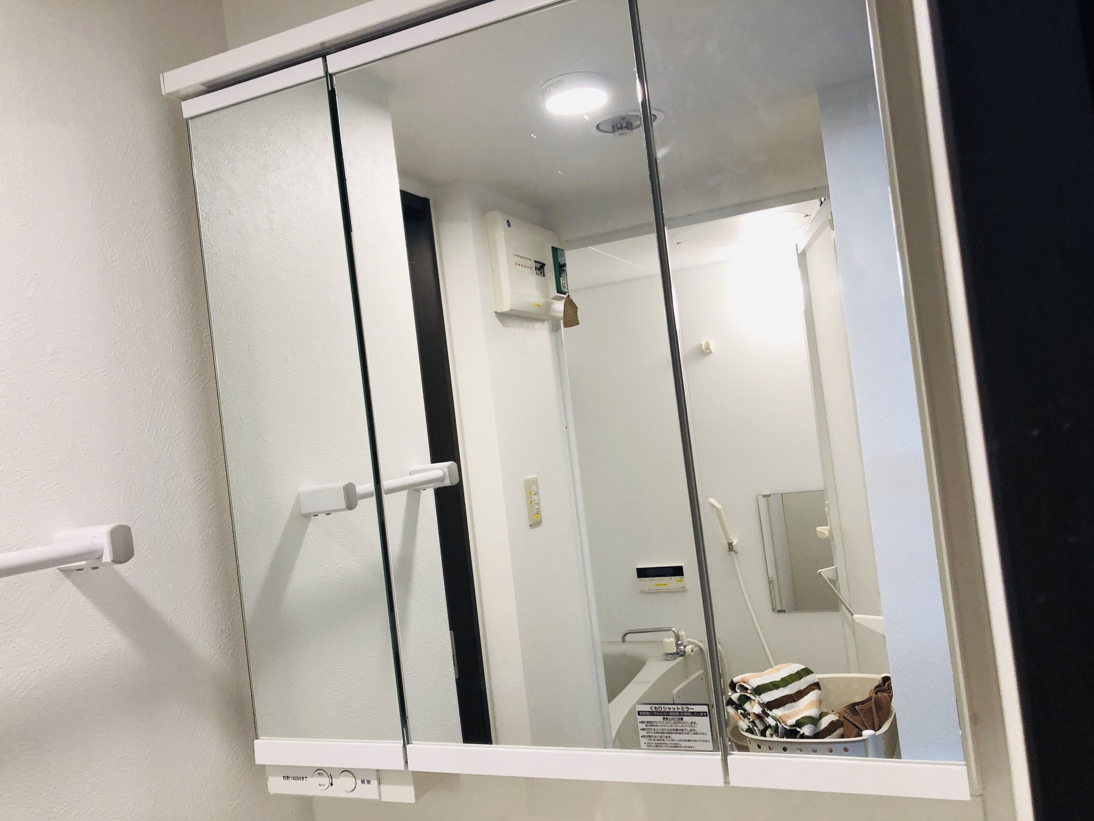 A bathroom with a glass partition, a white sink, a towel rack, and a shower area.
