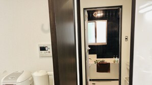 A modern bathroom with a white sink, a mirror, and a towel rack.