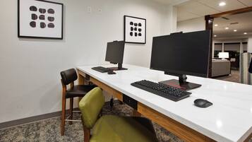 Un espacio de oficina moderno con un escritorio blanco, dos monitores, un teclado, un ratón y una silla verde.