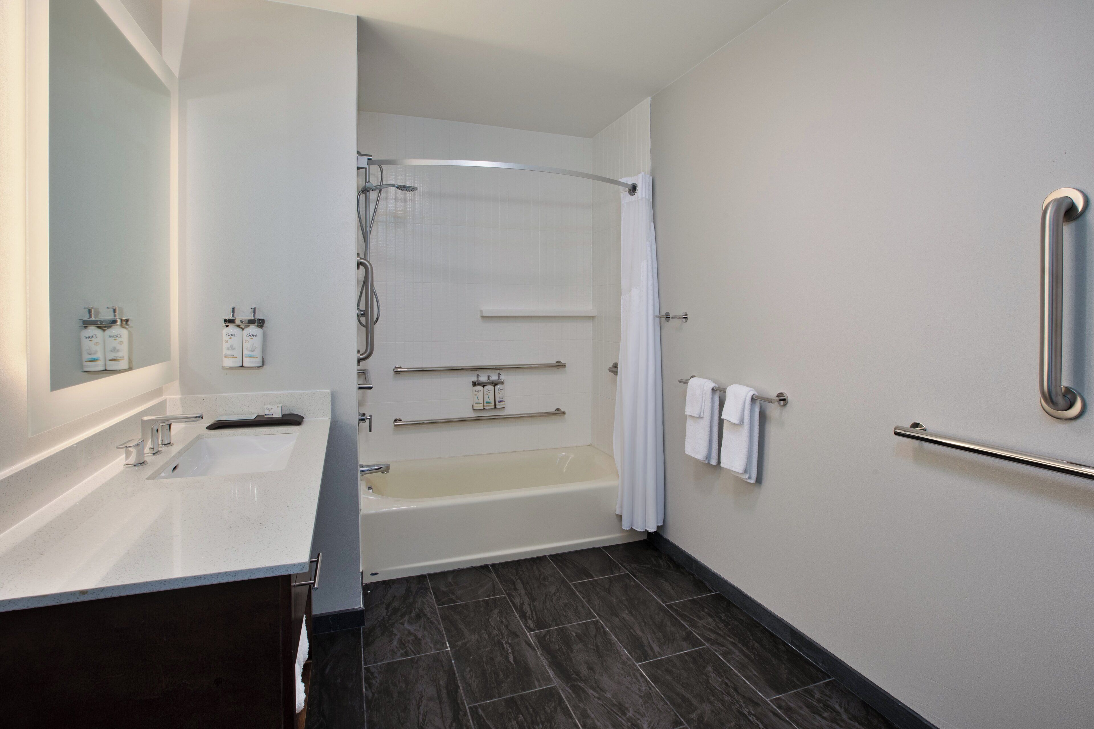 Un baño moderno con bañera, ducha y tocador con lavabo.