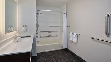 Un baño moderno con bañera, ducha y tocador con lavabo.