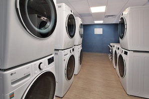 A laundry room with multiple LG Direct Drive washing machines. - Staybridge Suites Ames by IHG (Ames)