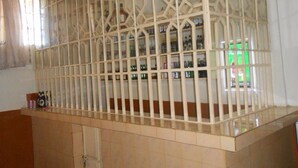 A room with a tiled floor, a wooden cabinet, and a decorative partition with shelves. - Sixty Two Paradise Hotel (Nanyuki)