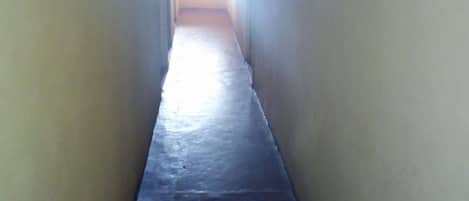 A narrow, dimly lit hallway with a light source at the end.