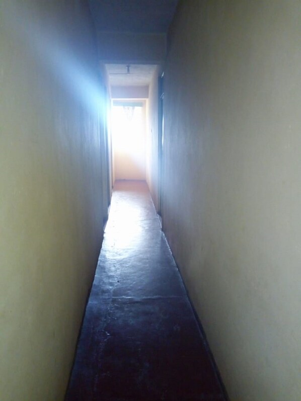 A narrow, dimly lit hallway with a light source at the end.