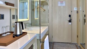 A modern bathroom with a glass shower enclosure, a white sink, and a coffee maker on the counter. - Shundi SHY Hotel West Lake Hangzhou (Hangzhou)