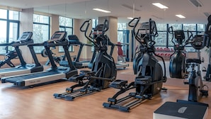 A gym with various exercise machines, large windows, and a wooden floor. - Shundi SHY Hotel Jinshan Lake Zhenjiang (Zhenjiang)