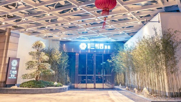 A hotel entrance with a modern architectural design, featuring a geometric ceiling structure and a red lantern. - Shundi SHY Hotel Jinshan Lake Zhenjiang (Zhenjiang)