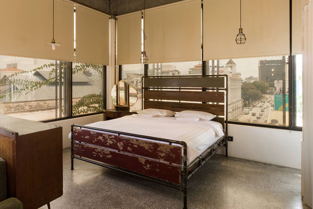 A bedroom with a bed, a desk, and a chair.