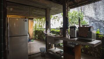 A compact kitchen with a refrigerator, sink, and microwave.