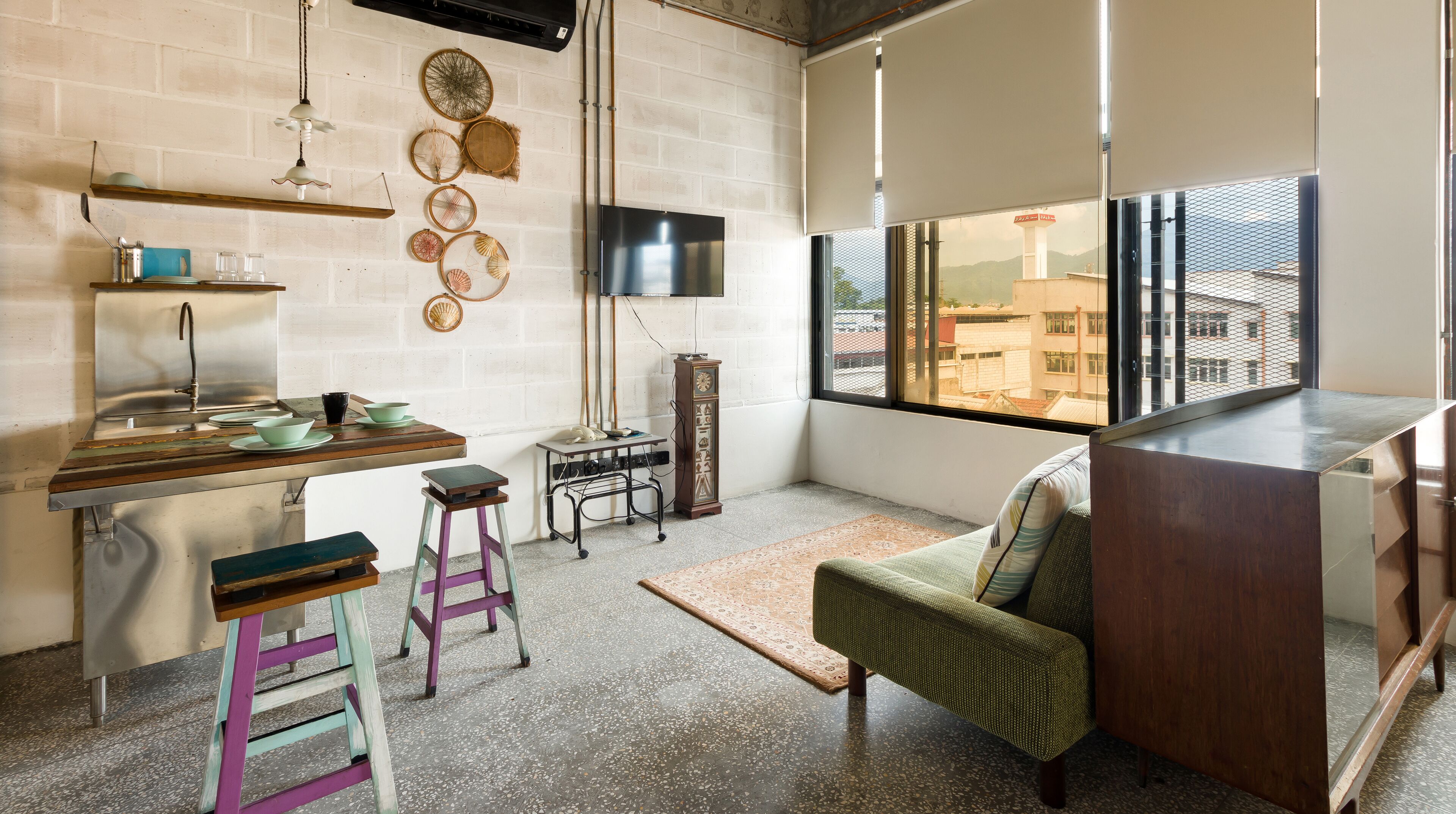 A compact kitchen with a built-in stove, a sink, and a window overlooking a cityscape.