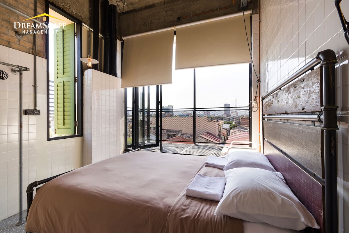 A hotel room with a large bed, a balcony with a view, and a sliding door.