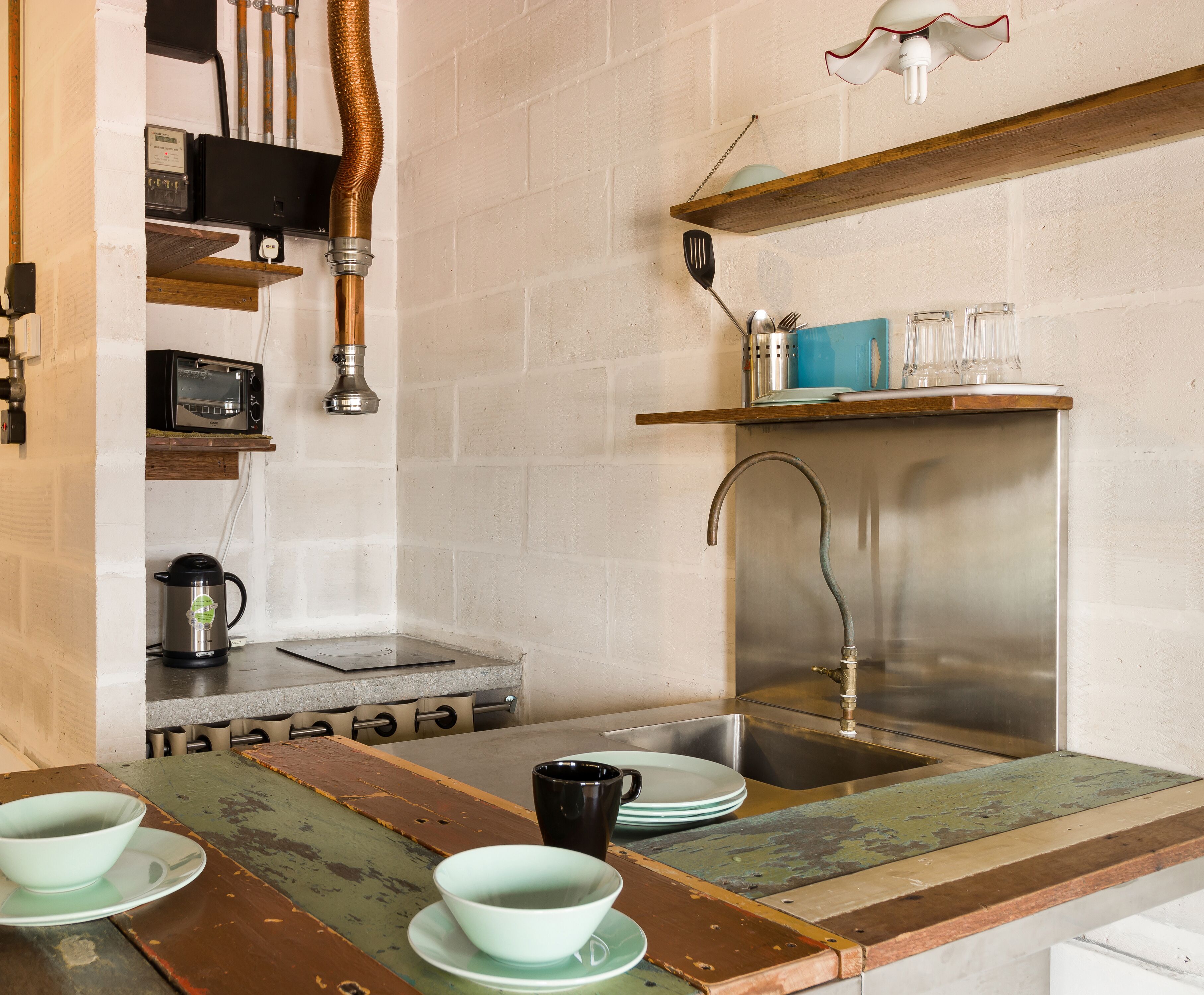 A kitchen with a sink, a stove, and a microwave.
