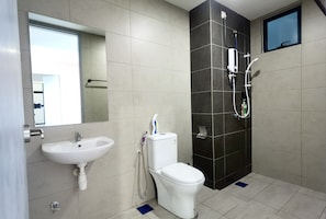 A modern bathroom with a sink, toilet, and shower.