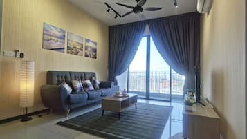 A modern living room with a sofa, coffee table, and a large window with curtains.