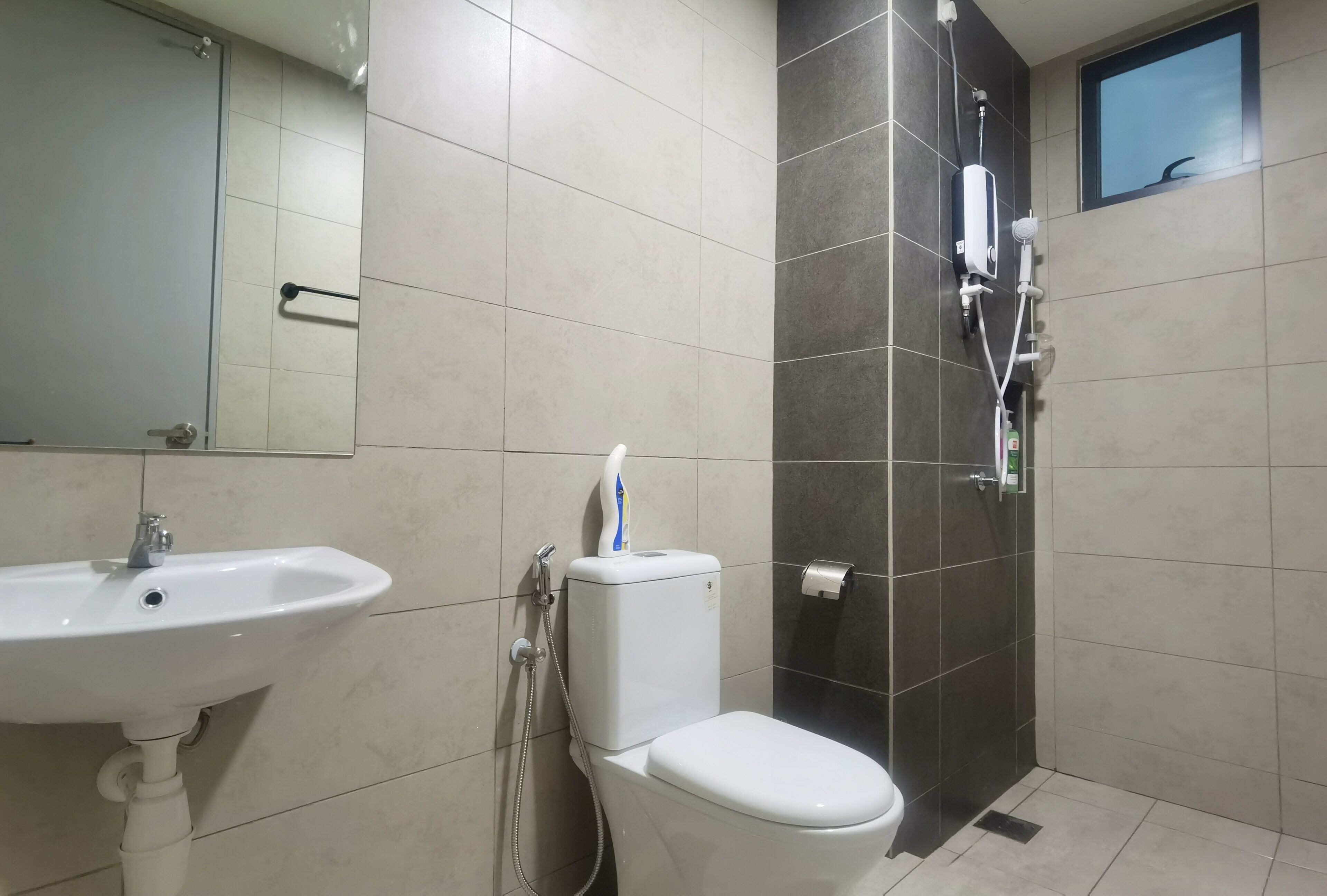 Et badeværelse med vask, toilet og brusebad.