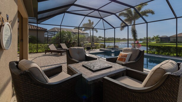 A covered outdoor area with wicker furniture, a pool, and a view of a golf course. - ⚓Lakeside home with private pool located in Golf & CC!⚓⛳ (Bradenton)
