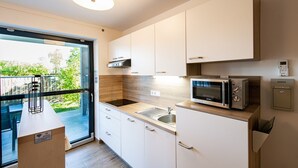 Eine moderne Küche mit weißen Schränken, einer Mikrowelle und einem eingebauten Backofen.