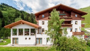 A two-story building with a wooden facade and a sign reading "untera". - Hotel Cuntera (Medel)