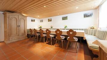 A dining area with a long table, several chairs, a bench, and a cabinet.