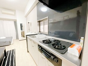 Eine moderne Küche mit einem Gasherd, einem Spülbecken und einem Fenster.