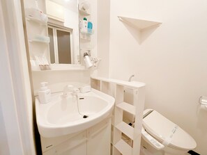 Ein Badezimmer mit Waschbecken, Spiegel und Toilette.