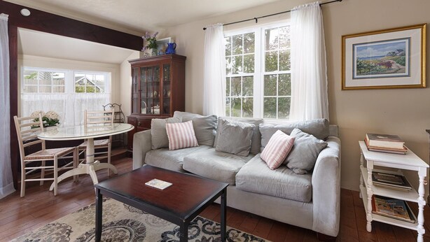 A cozy living room with a sofa, a glass table, and a cabinet.