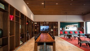 A modern meeting room with a wooden table, chairs, and a large TV screen. - FRITZTOWER - Apartment (Mitte)