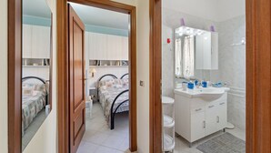 Une chambre à coucher avec un lit, une table de chevet et une armoire.