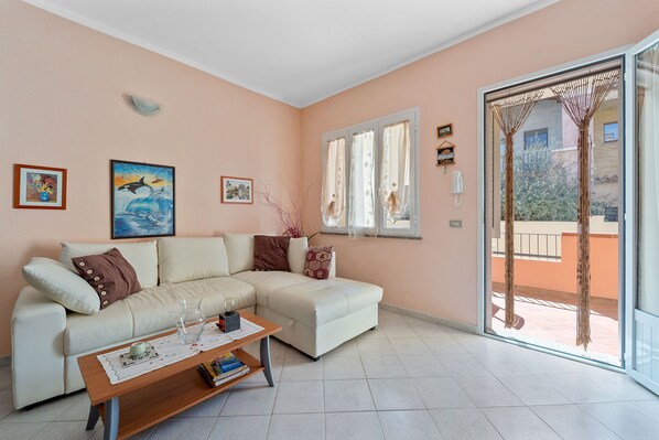 A living room with a sofa, coffee table, and artwork on the wall.
