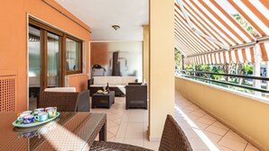 A balcony with wicker furniture, a glass table, and a view of the outdoor area. - Brand new with terrace, solarium, gym&tennis court (Sorrento)