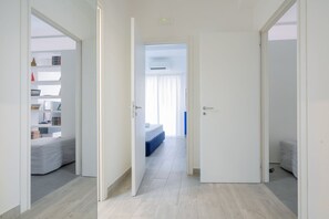 A hallway leading to a bedroom with a bed and a window. - Modern spacious apartment with terrace, balconies, solarium & gym (Sorrento)