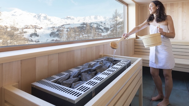 Una persona en un spa con vistas a montañas nevadas.