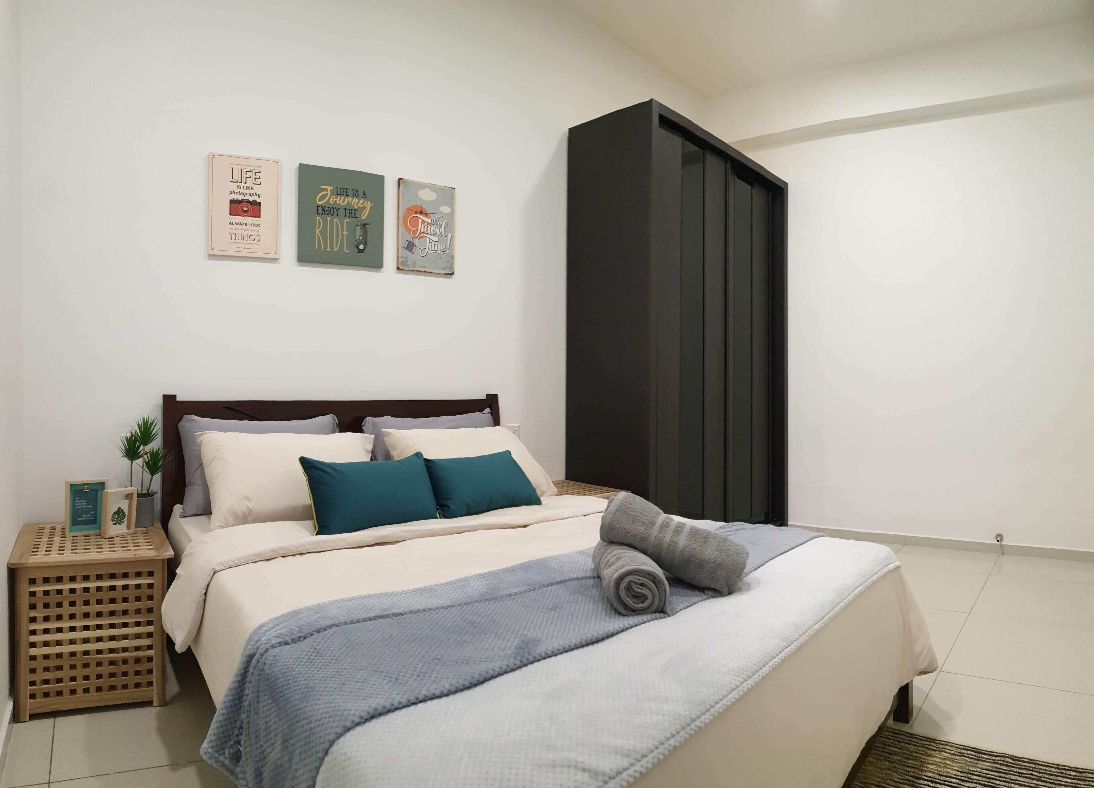 Ein Schlafzimmer mit Bett, Kissen, einem Nachttisch und Wandbildern.