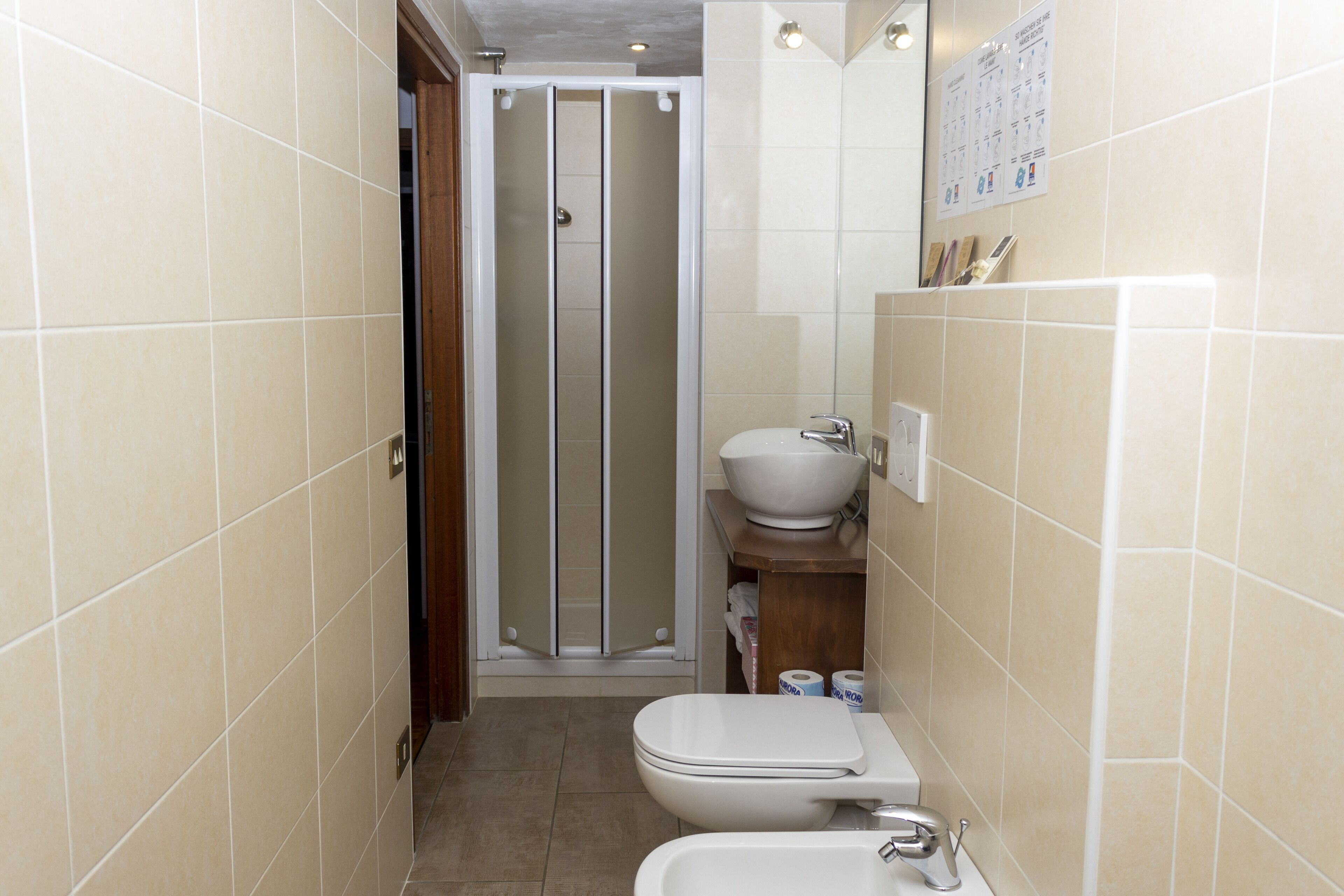 A bathroom with a toilet, bidet, and shower stall.