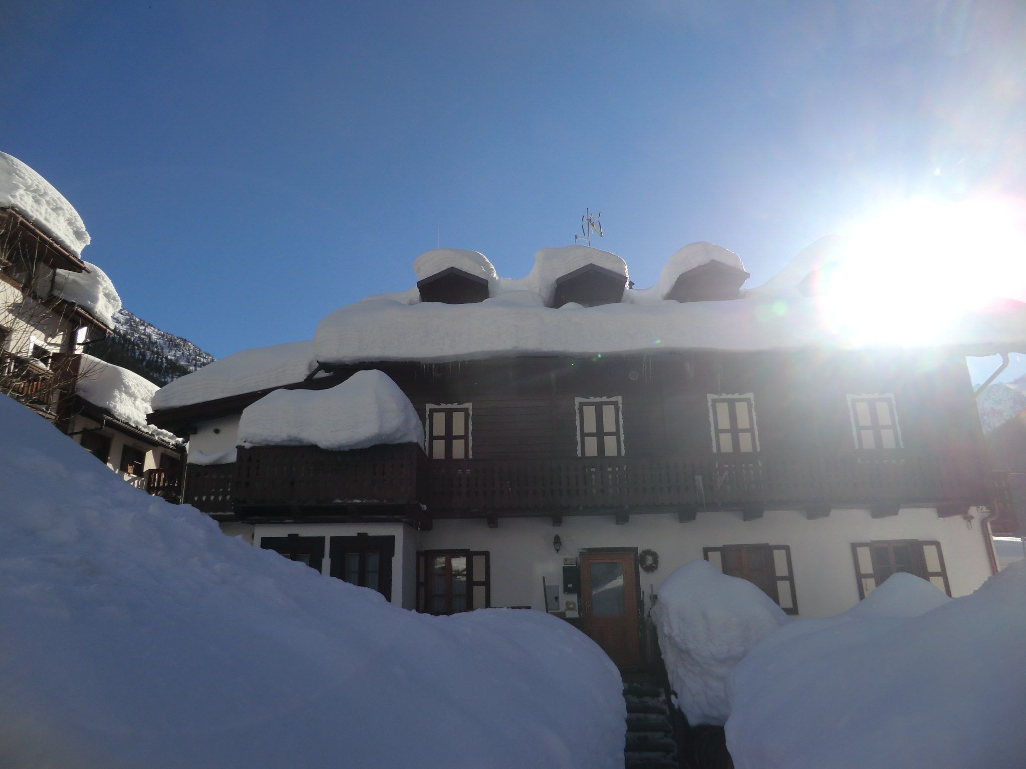 Un edificio cubierto de nieve con múltiples ventanas y fachada de madera.