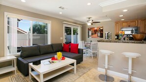 A modern living room with a sofa, coffee table, and a dining area with chairs. - Costa Mesa/Newport - Fast WiFI - Work Stations - Free Parking - Self Check In! (CM-1) (Costa Mesa)