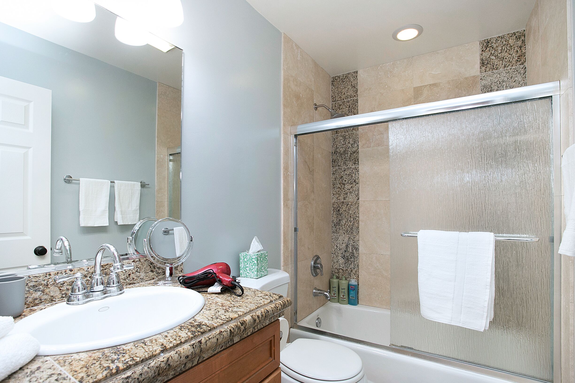 Une salle de bain avec un lavabo, un miroir et des toilettes.