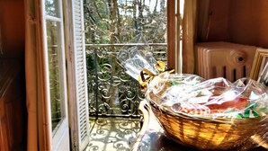 Un panier en osier recouvert d’un film plastique, posé sur la rambarde d’un balcon.