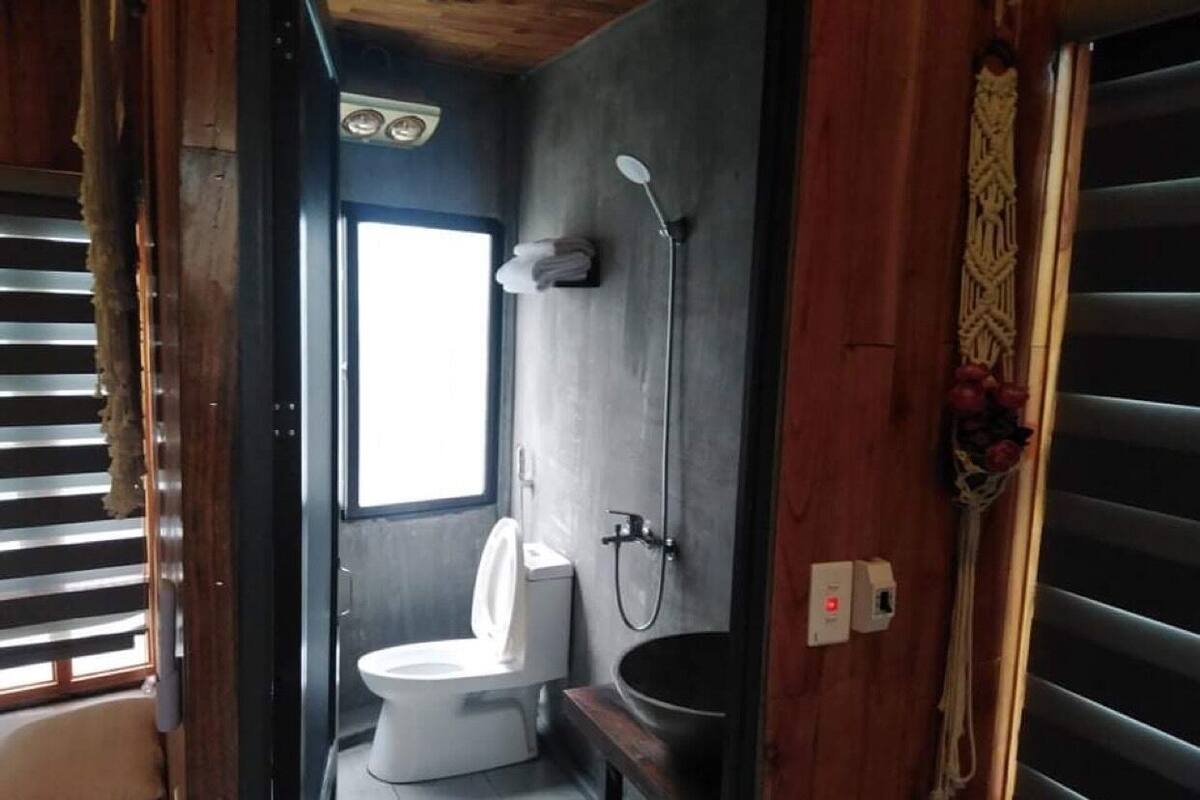 Een kleine badkamer met toilet, wastafel en douche.