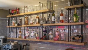 A bar area with shelves of liquor bottles and glasses, a coffee machine, and a sign that reads "SMILES BEGIN WITH YOU". - Pure Blanche Hotel (Antalya)