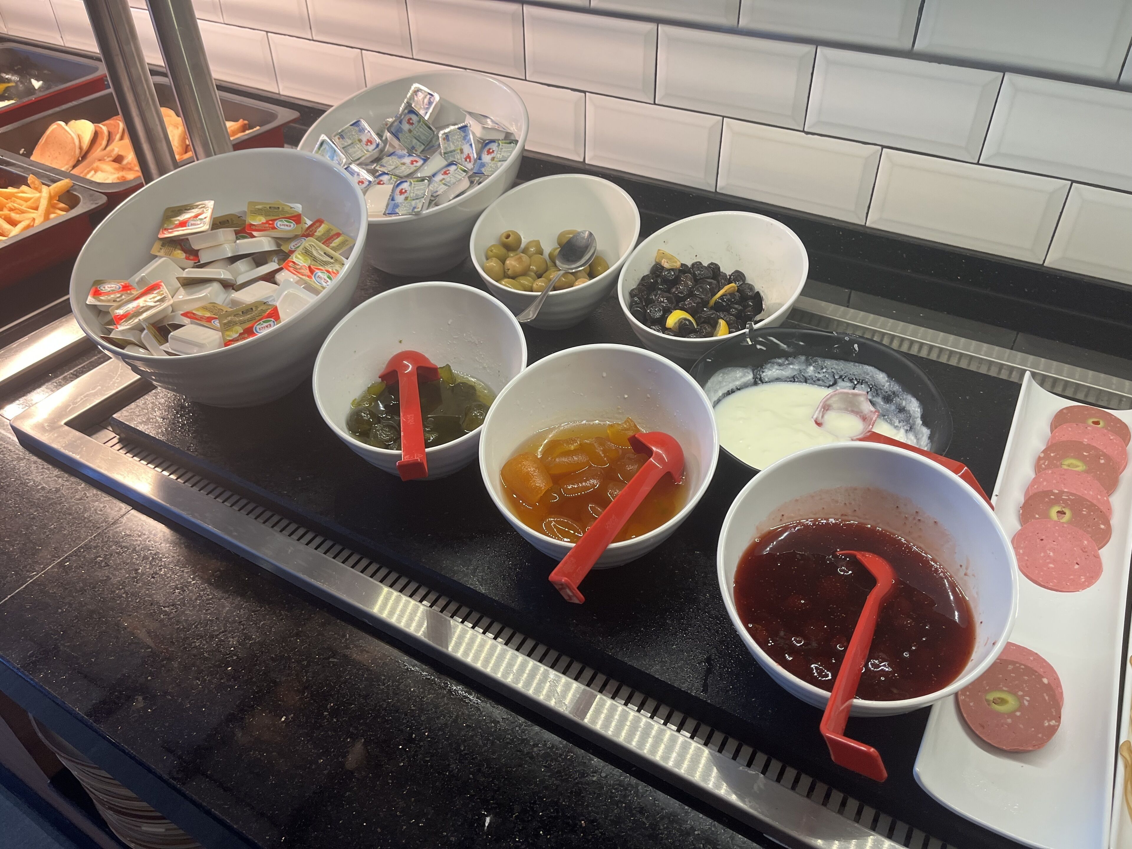 Un buffet proposant une variété de plats, notamment des salades, des viandes et des accompagnements.