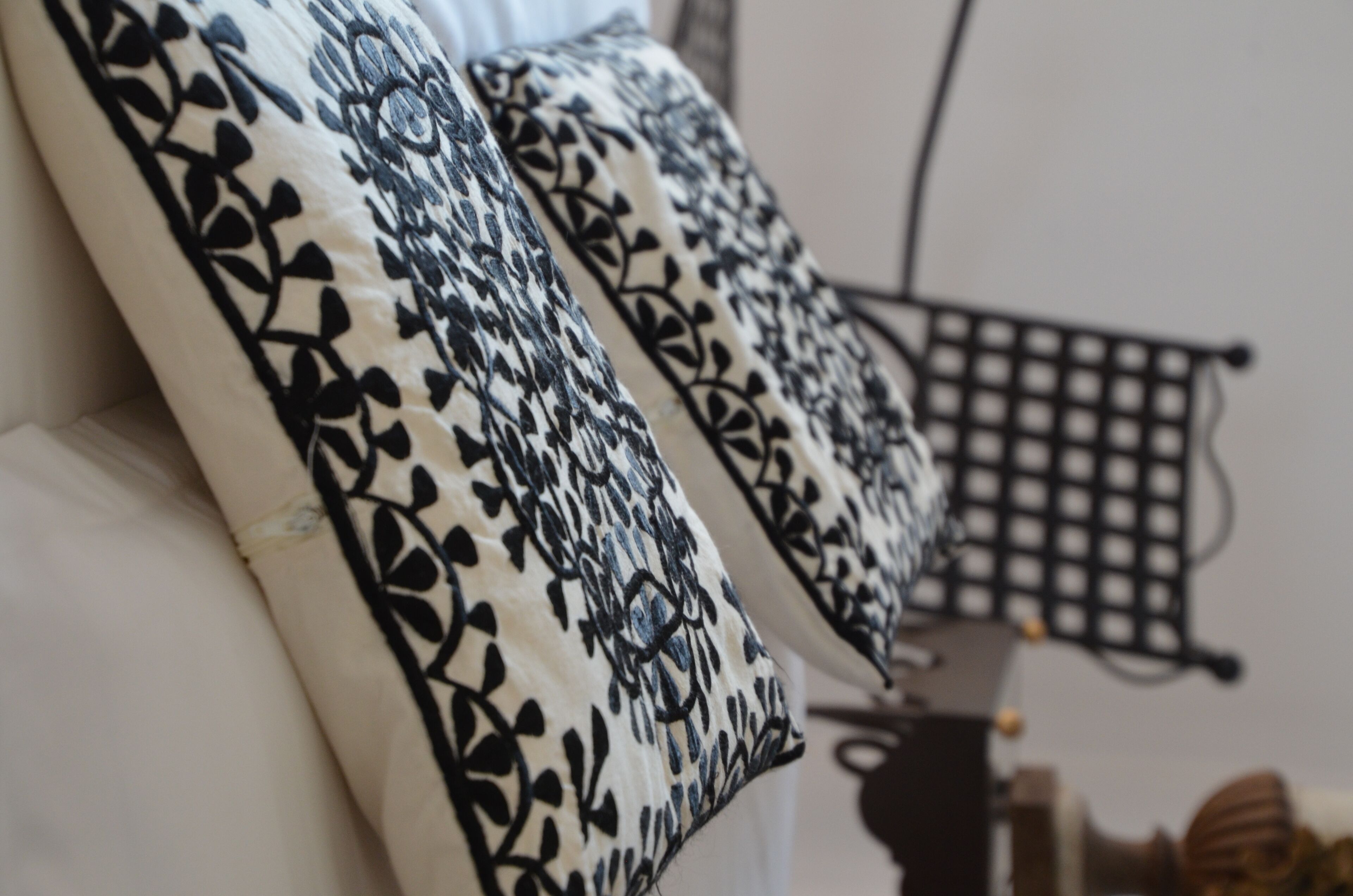 Un gros plan d’un coussin orné d’un motif floral noir et blanc.