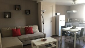 Un salon comprenant un canapé, une table basse et un coin repas avec une table et des chaises.